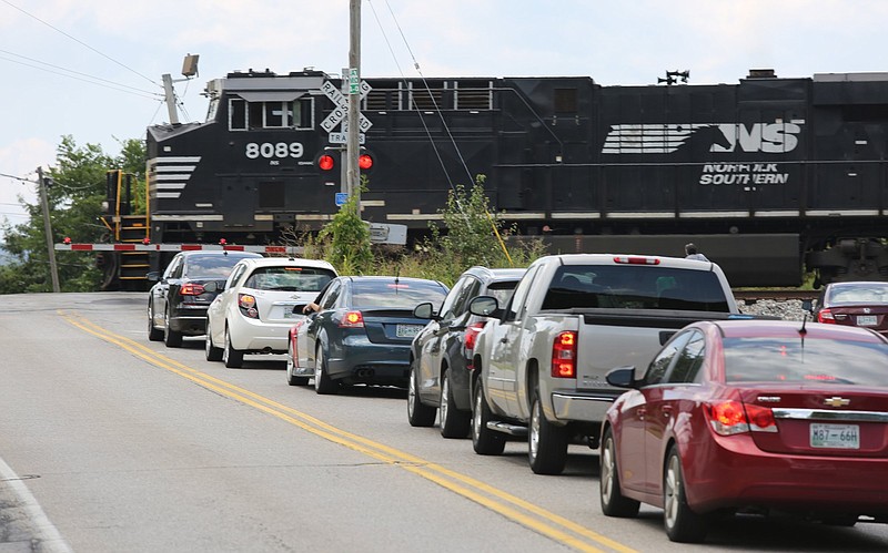 Staff photo by Erin O. Smith / Cars get backed up as a train passes across Hamill Road Friday, July 26, 2019, in Hixson, Tennessee. Hixson residents complain that Norfolk Southern trains regularly block traffic at railroad crossings on Hamill Road and Thrasher Pike.