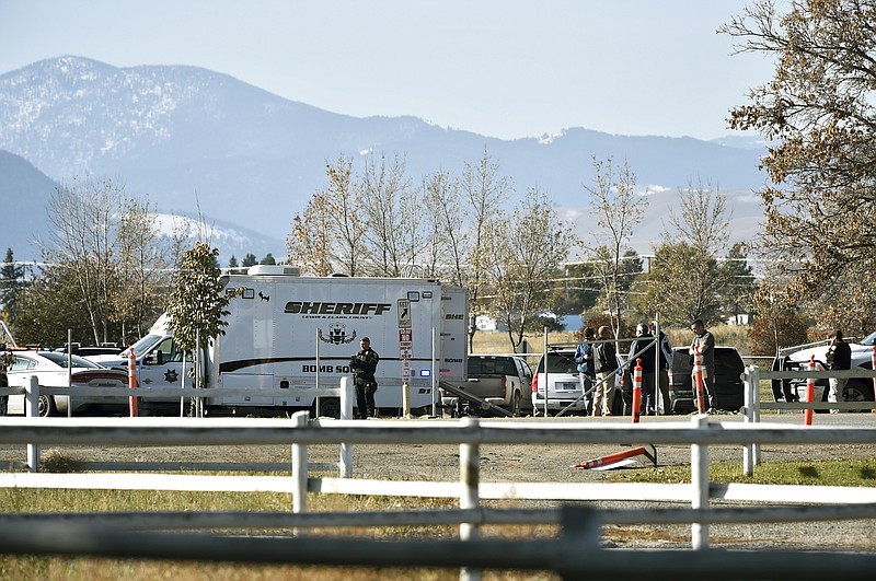 The Lewis and Clark County bomb squad works the scene at Rossiter Elementary School in Helena, Mont., Tuesday, Oct. 15, 2019, after authorities found what they thought were the remnants of an improvised explosive device on the school playground. Authorities evacuated the elementary school in Montana's capital city Tuesday after officials found the unknown materials, but they turned out to be a plastic bottle filled with nuts and bolts left in the schoolyard. (Thom Bridge/Independent Record via AP)