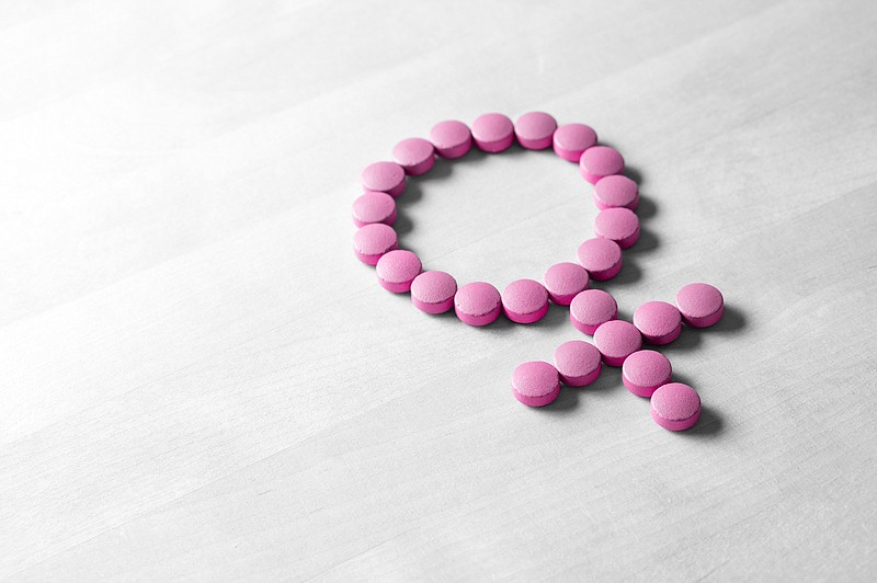 Medicine for woman. Menopause, pms, menstruation or estrogen concept. Female health. Gender symbol made from pink red pills or tablets on wooden table. - stock photo women health women's health tile woman tile female tile birth control contraception / Getty Images
