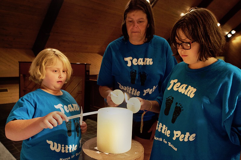 Staff photo by Wyatt Massey / Melissa Alexander, center, and her daughters McKenna, left, and Karagan, right, light candles for the child Melissa lost in 2011. They participated in the National Day of Remembrance for Pregnancy and Infant Loss on October 16 at St. Thaddeus Episcopal Church. 