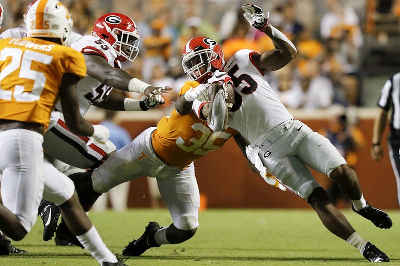 Staff photo by C.B. Schmelter / Tennessee linebacker Daniel Bituli tackles Georgia running back Brian Herrien on Oct. 5 at Neyland Stadium. Tennessee lost 43-14 that night but bounced back to put together an outstanding defensive performance last Saturday in a 20-10 win against Mississippi State.