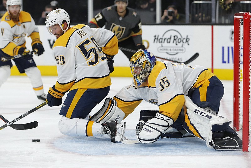 Nashville Predators goaltender Pekka Rinne (35) and defenseman Roman Josi (59) keep the puck away from the net during the second period of the team's NHL hockey game against the Vegas Golden Knights, Tuesday, Oct. 15, 2019, in Las Vegas. (AP Photo/John Locher)