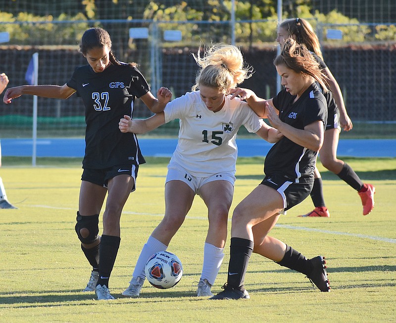 Staff photo by Patrick MacCoon / GPS defenders Megan Jones, left, and Meg Priest close in to take the ball away from a Knoxville Catholic attacker in the Division II-AA East Region championship match Thursday night. The host Bruisers won 3-0.