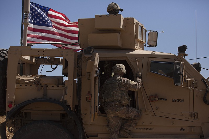 In this Sept. 8, 2019, photo, a U.S. soldier climbs into an armored vehicle during the first American-Turkish joint patrol in the so-called "safe zone" on the Syrian side of the border with Turkey near Tal Abyad, Syria. (AP Photo/Maya Alleruzzo)