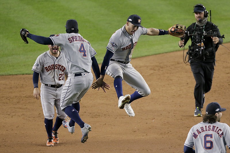 AP photo by Seth Wenig / Houston Astros center fielder George Springer (4) and shortstop Carlos Correa leap in celebration after Thursday night's win against the host New York Yankees 8-3 in Game 4 of the AL Championship Series.