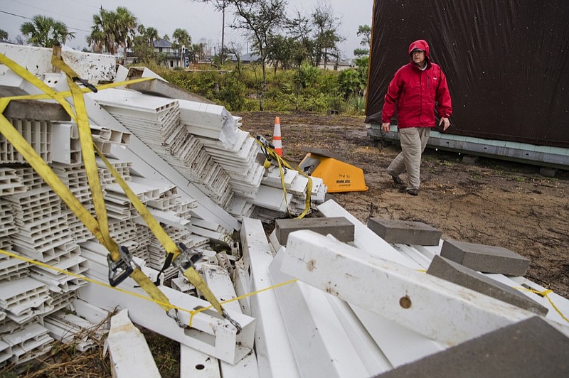 Chris Anderson ties down building materials and other objects from his lawn as Tropical Storm Nestor approaches, Friday, Oct. 18, 2019 in Mexico Beach, Fla.. Forecasters say a disturbance moving through the Gulf of Mexico has become Tropical Storm Nestor. The National Hurricane Center says high winds and dangerous storm surge are likely along parts of the northern Gulf Coast. Conditions are expected to deteriorate Friday into early Saturday. (Joshua Boucher/News Herald via AP)