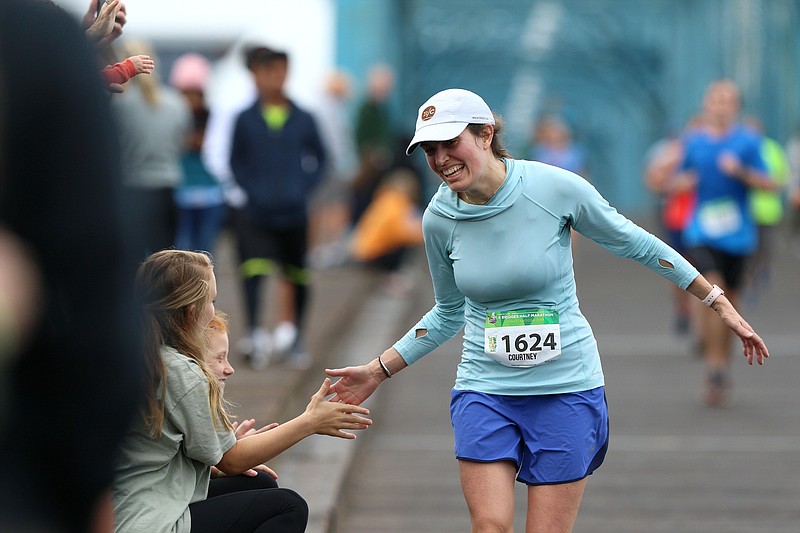 Staff photo by Erin O. Smith / Courtney Poore high fives onlookers as she runs the 4 Bridges Half Marathon Sunday, October 20, 2019 in Chattanooga, Tennessee. 