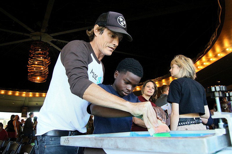 Staff photo by Erin O. Smith / Leo Ascarate works with Elijah Roper to make a t-shirt during Teacherpreneur Pitch Night at the Chattanooga Whiskey Event Hall Sunday, October 20, 2019 in Chattanooga, Tennessee. The event kicked off Start Up Week.