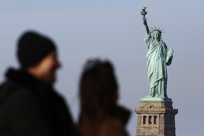 In this Jan. 21, 2018, file photo, tourists ride the Staten Island Ferry to get a view of the Statue of Liberty in New York. A new poll from The Associated Press-NORC Center for Public Affairs Research shows majorities of Americans agree that diversity is a strength and that values such as constitutional rights, a fair judicial system and the American Dream are key to the nation's identity. But the poll shows Americans are closely split over whether it's better for immigrants to embrace a single U.S. culture or add their own variations to the mix. (AP Photo/Mark Lennihan, File)