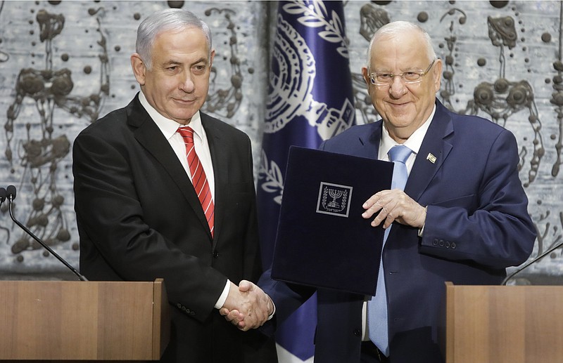 In this Sept. 25, 2109 file photo, Israeli President Reuven Rivlin, right, shakes hands with Israeli Prime Minister Benjamin Netanyahu in Jerusalem. Rivlin said Monday, Oct. 21, 2019, that Prime Minister Benjamin Netanyahu has ended his quest to form a new coalition government -- a step that pushes the country into new political uncertainty. Netanyahu fell short of securing a 61-seat parliamentary majority in last month's national election. (AP Photo/Sebastian Scheiner, File)