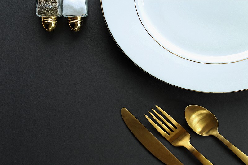 silverware gold Elegant white, gold and black table setting. Copy space. food restaurant formal dinner menu / Getty Images
