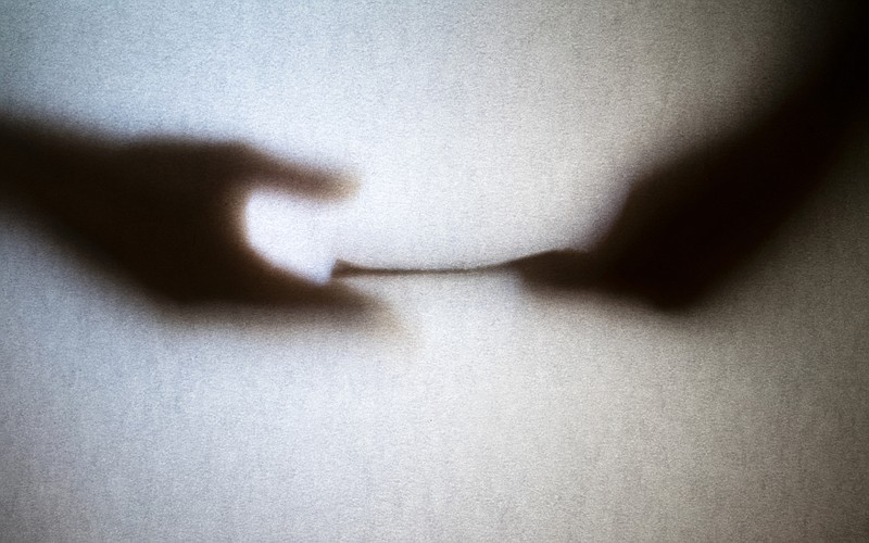 Silhouette of business man hands giving bribe isolated on grey background scam tile charity scam tile / Getty Images
