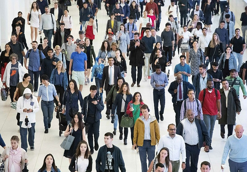 FILE - In this June 21, 2019, file photo, commuters walk through a corridor in the World Trade Center Transportation Hub, in New York. The United States will add 79 million people in the next 40 years, but growth will slow as the U.S population gets older, according to new projections presented Thursday at a meeting of demographers. (AP Photo/Mark Lennihan, File)