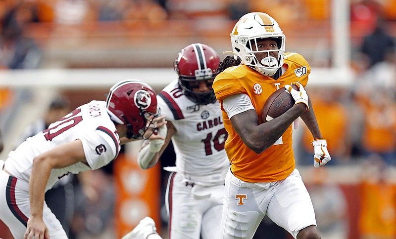 AP photo by Wade Payne / Tennessee wide receiver Marquez Callaway outruns South Carolina punter Joseph Charlton, left, and defensive back R.J. Roderick for a touchdown in the first half of Saturday's SEC East matchup at Neyland Stadium in Knoxville.
