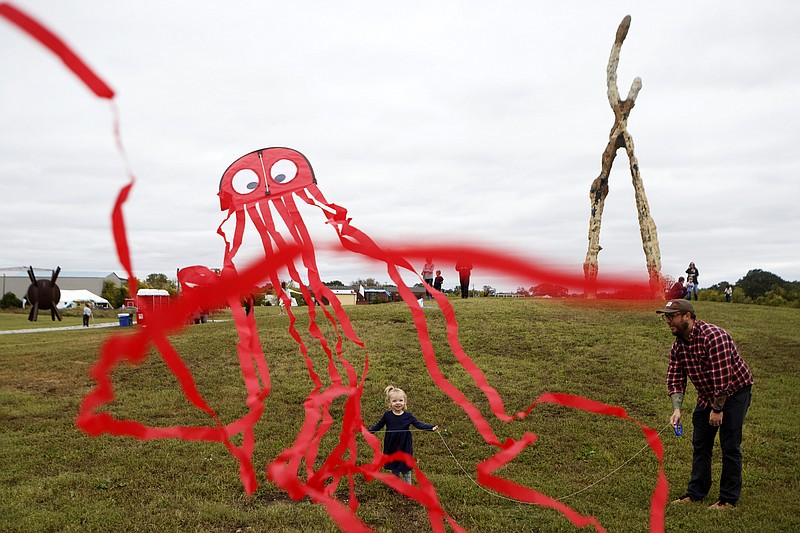 Staff photo by C.B. Schmelter / One-year-old Willow, center, helps her dad Jerod Walz fly a kite during Spooktacular Sculptures in the Sky at the Sculpture Fields at Montague Park on Sunday, Oct. 27, 2019 in Chattanooga, Tenn. The event was originally suppose to be held on Oct. 26 but got moved to Sunday because of the weather.