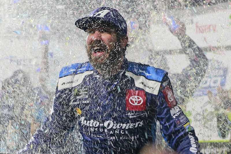 AP photo by Steve Helber / Martin Truex Jr. is doused with water and confetti after winning Sunday's NASCAR Cup Series race at Martinsville Speedway in Virginia.