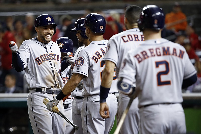 AP photo by Patrick Semansky / The Houston Astros' George Springer, left, celebrates after hitting a two-run homer against the Washington Nationals during the ninth inning of Game 5 of the World Series on Sunday night in Washington.