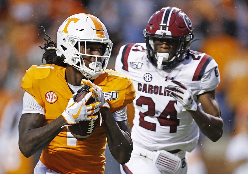 AP photo by Wade Payne / Tennessee wide receiver Marquez Callaway catches a pass and runs for a touchdown as he's chased by South Carolina defensive back Israel Mukuamu during the second half of Saturday night's game at Neyland Stadium.