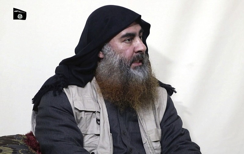 FILE - This file image made from video posted on a militant website April 29, 2019, purports to show the leader of the Islamic State group, Abu Bakr al-Baghdadi, being interviewed by his group's Al-Furqan media outlet. The IS erupted from the chaos of Syria and Iraq's conflicts and swiftly did what no Islamic militant group had done before, conquering a giant stretch of territory and declaring itself a "caliphate." U.S. officials said late Saturday, Oct. 26, 2019 that al-Baghdadi was the target of an American raid in Syria and may have died in an explosion. (Al-Furqan media via AP, File)