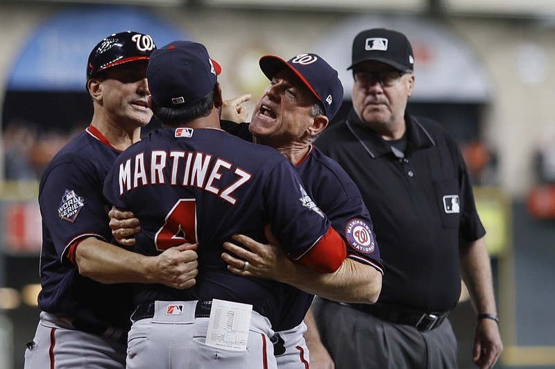 Washington Nationals manager Dave Martinez has to be restrained after being ejected for arguing an interference call during the seventh inning of Game 6 of the baseball World Series against the Houston Astros Tuesday, Oct. 29, 2019, in Houston. (AP Photo/Matt Slocum)