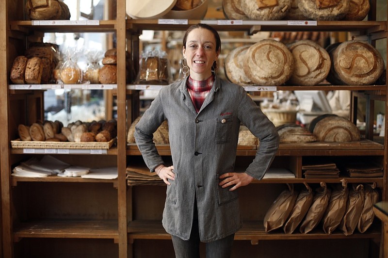 This Oct. 9, 2019 photo shows third generation baker Apollonia Poilâne posing in the  Poilâne bakery, in Paris. She has authored her first English-language cookbook, “Poilâne: The Secrets of the World-Famous Bread Bakery," with a weighty collection of nearly 100 recipes. (AP Photo/Thibault Camus)