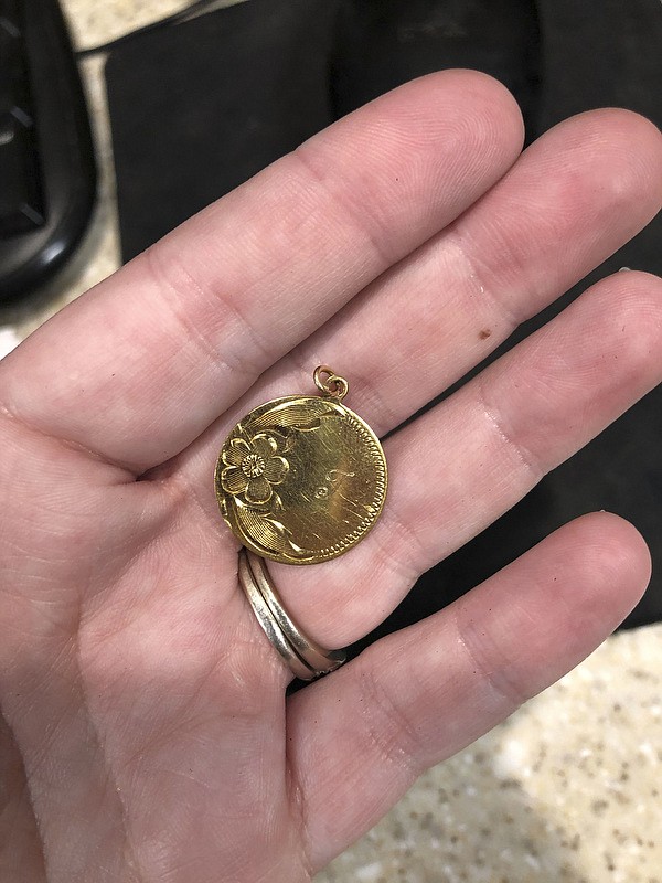 Contributed Photo by Shelby Stalans/ Shelby Stalans, a clerk at a convenience store in Dalton, Georgia, shows a pendant she is trying to return to its owner.