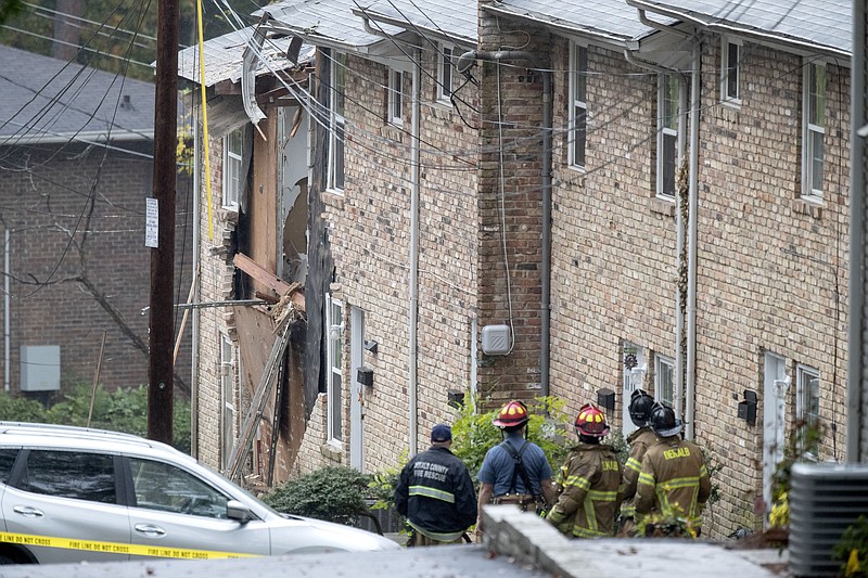 Fire officials look at the scene where an airplane crashed into an apartment complex, Wednesday, Oct. 30, 2019, in Atlanta. (AP Photo/David Goldman)