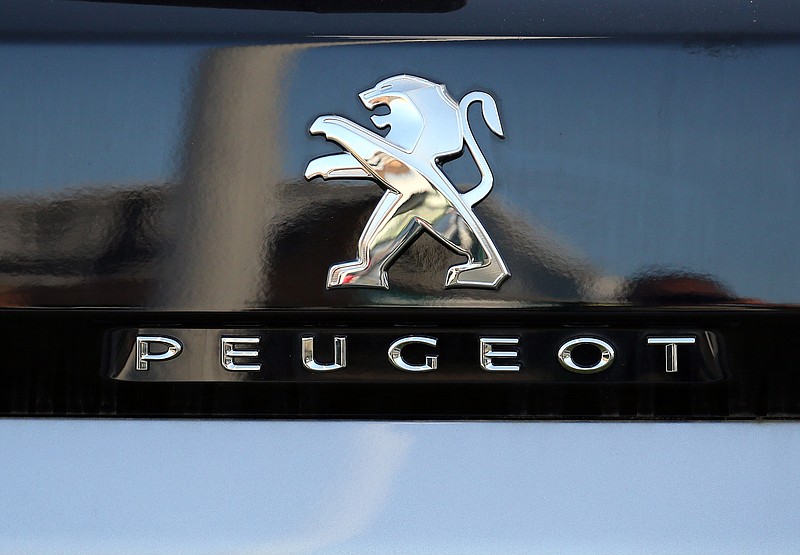 A Peugeot logo pictured on a car in Bayonne, southwestern France, Thursday, Oct.31, 2019. The boards of Fiat Chrysler and PSA Peugeot announced Thursday fast-moving plans to merge the two companies creating the world's fourth-largest automaker with enough scale to confront "the new era in mobility". (AP Photo/Bob Edme)