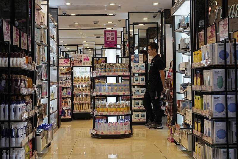 n this Oct. 30, 2019, photo, a salesman waits for customers at a cosmetic shop in a shopping district in Hong Kong. Business has plunged in Hong Kong's shopping districts after more than four months of protests. The government announced Thursday, Oct. 31, that the city is in a technical recession after it contracted for a second straight quarter.(AP Photo/Vincent Yu)