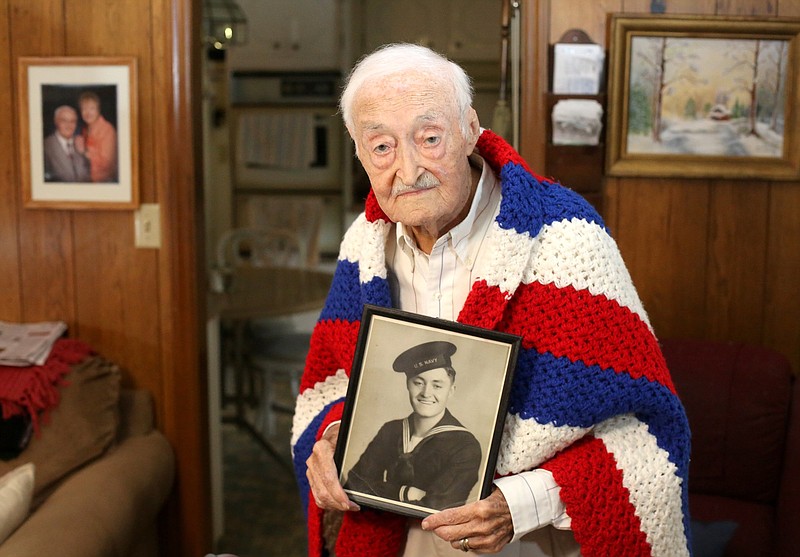 Staff photo by Erin O. Smith / Robert Rayburn poses for a photo with his Navy photo at his home Tuesday, October 15, 2019 in Chattanooga, Tennessee. Rayburn is a Navy veteran of World War II. Rayburn took part in several battles, including Leyte Gulf and the Battle of Midway.