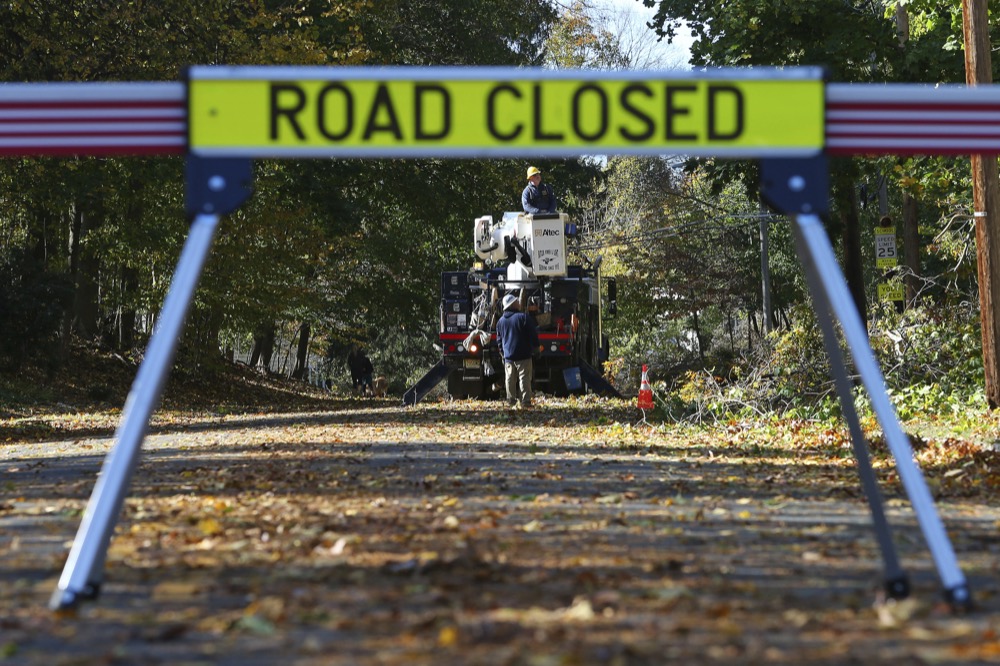 Crews from Butler Municipal Power and Light work on downed power lines on Green Village Road, Friday, Nov. 1, 2019, in Madison, N.J. The borough was hit by high winds on heavy rain late the night before. (AP Photo/Rich Schultz)