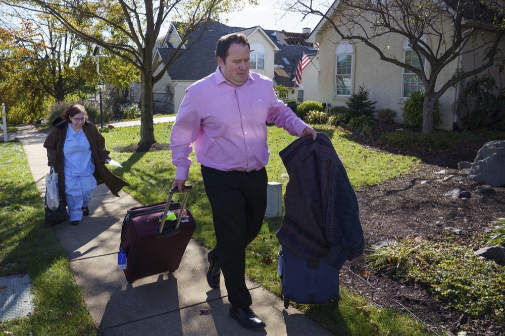 Matt Mangold, front center, a State Farm Insurance Agent, helps his client Cheryl Mann, back left, leave the street where her damaged home is, on Chelsea Court, in Thornbury Township, PA, where a severe storm hit the area last night, November 1, 2019.