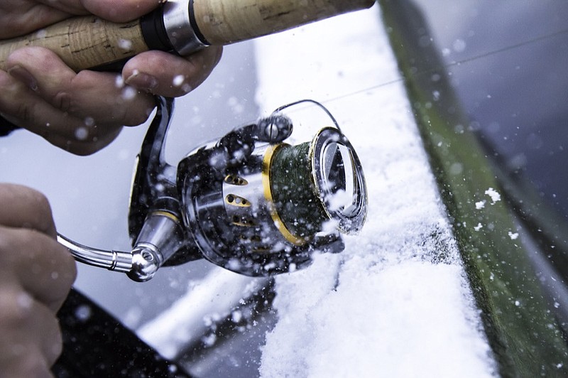 Fishing reel in very cold weather. fishing winter tile / Getty Images
