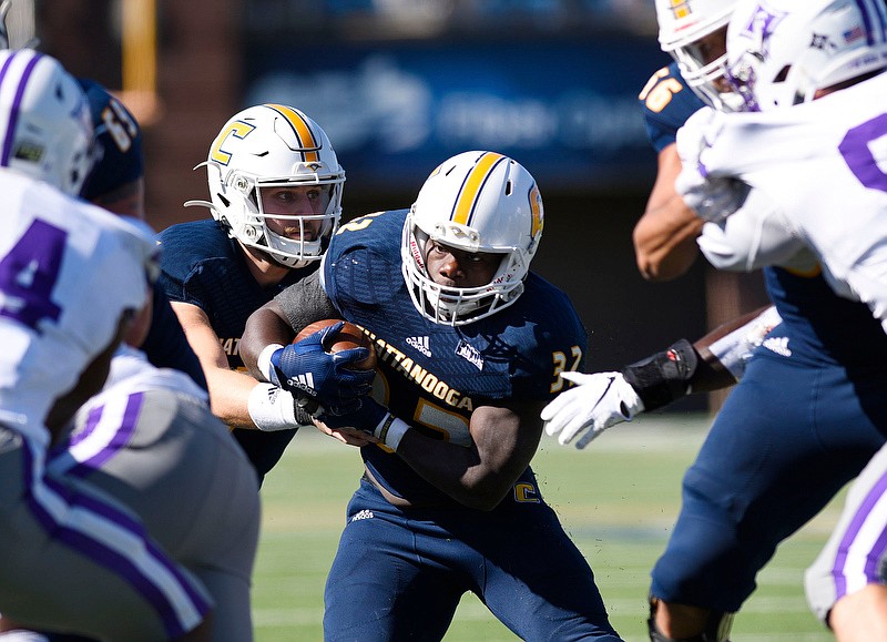 Staff Photo by Robin Rudd/  UTC's Ailym Ford (32) looks for running room as he takes the handoff from Nick Tiano (7). The University of Tennessee at Chattanooga Mocs hosted the Furman Paladins in a Southern Conference football game at Finley Stadium on November 2, 2019.