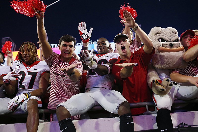 AP photo by Joshua L. Jones / Georgia defensive back J.R. Reed (20) does the "gator chop" with fans in celebration after the Bulldogs beat Florida on Saturday in Jacksonville.