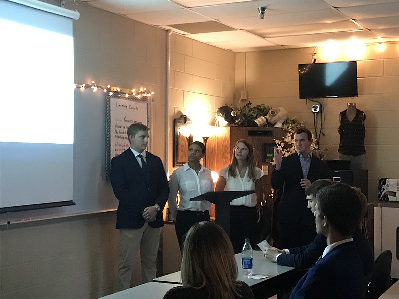 Staff photo by Emily Crisman / Ooltewah High School advanced marketing students Logan Siatkowski, Jenna Elston, Shaina Teal and Jake Holcomb, from left, present the school they designed for a class project to Hamilton County Schools officials.