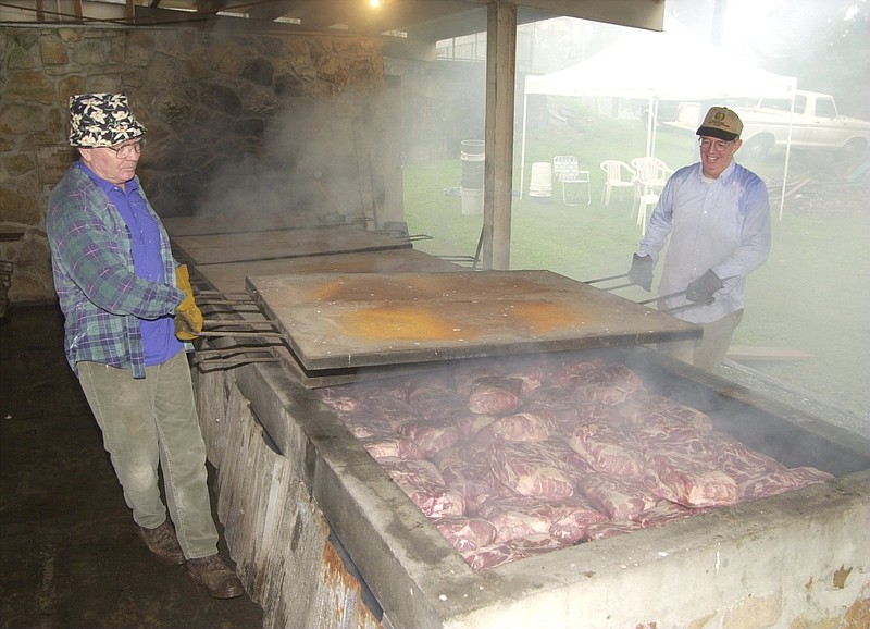 Staff file photo / Signal Mountain Lions Club members Jerry Childers, left, and Earl Here smoke pork in 2001 on the barbecue pits the club built in Althaus Park. The pits have been removed for safety reasons, and the club wants permission from the Signal Mountain Town Council to enclose the structure for storage purposes.