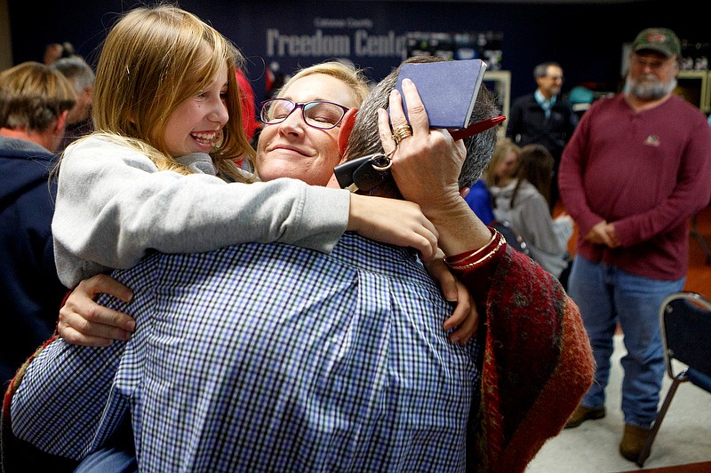 Staff photo by C.B. Schmelter / Holding his 8-year-old daughter Molly, left, Mayor Nick Millwood hugs his wife Lori, center, after election results were read, giving him the victory, inside the Catoosa County Freedom Center on Tuesday, Nov. 5, 2019 in Ringgold, Ga.