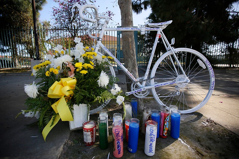 FILE - In a Wednesday, April 11, 2018 file photo, a painted bicycle marks a makeshift memorial for a cyclist who was struck by a hit-and-run motorist in Los Angeles. The National Transportation Safety Boar is recommending that all 50 states enact laws requiring bicyclists to wear helmets to stem an increase in bicycle deaths on U.S. roadways, after a hearing Tuesday, Nov. 5, 2019 on bicycle safety. (AP Photo/Damian Dovarganes, File)