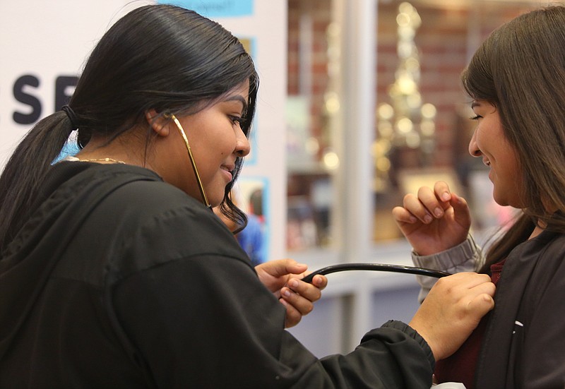 Staff photo by Erin O. Smith / Isabel Tomas listens to Kimberly Lopez's heart beat during a health care career fair held at The Howard School Thursday, November 7, 2019 in Chattanooga, Tennessee. The career fair was held for students who are part of the Erlanger Institute for Healthcare and Innovation.