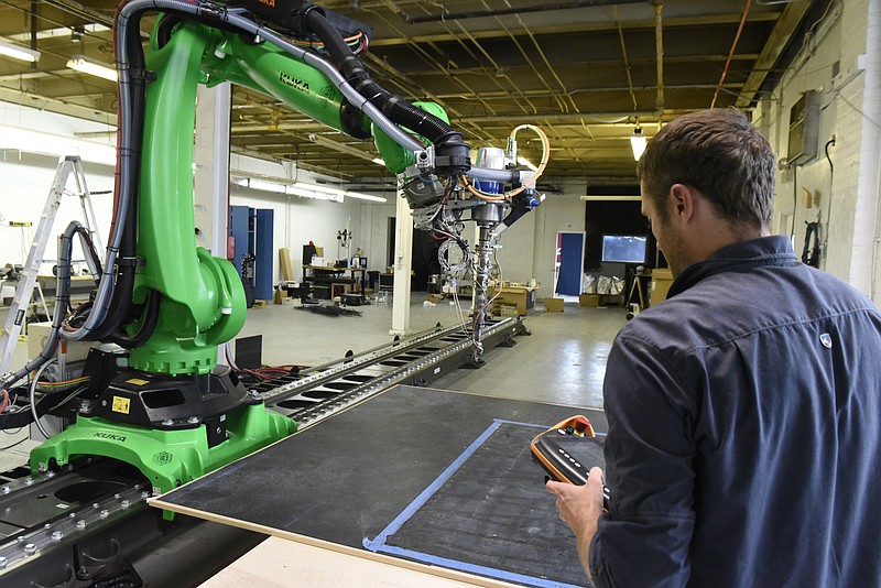 Staff file photo / A mechanical engineer and roboticist at Branch Technology prepares to use company's giant 3D printer that he designed and built in this file photo. Branch Technology has combined industrial robotics and 3D printing to manufacture structural components used in high-end architecture.
