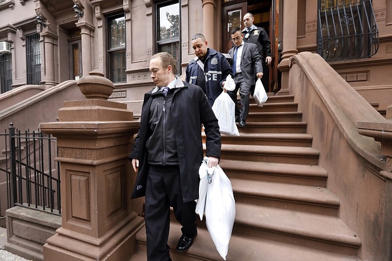 New York City Police Department personnel carry bags from a residential building in New York's Harlem neighborhood, Thursday, Nov. 7, 2019. The NYPD says three people, including a child, are dead in what's being investigated as a double homicide and a suicide. (AP Photo/Richard Drew)


