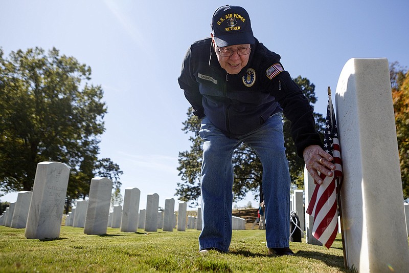 Staff photo by C.B. Schmelter / Wilbourne Markham reads his twin brother's headstone in the Chattanooga National Cemetery on Thursday, Oct. 17, 2019 in Chattanooga, Tenn. After his twin brother, Weldon, failed his physical, Wilbourne went back and took the physical in his place. They were both sworn in and served in the United States Air Force.