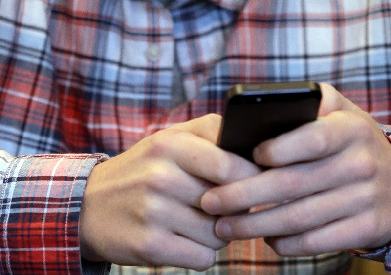 FILE - In this Oct. 24, 2013, file photo, a person checks their smartphone in Glenview, Ill. (AP Photo/Nam Y. Huh, File)


