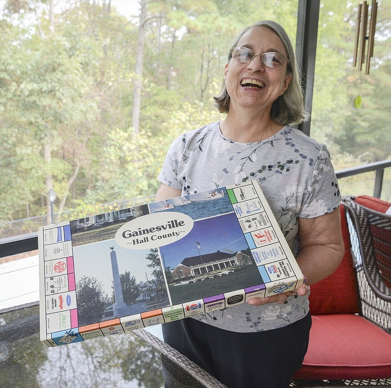 In this Tuesday, Oct. 29, 2019 photo, Rosemary Goolsby, of Gainesville, Ga., poses with a Gainesville-Hall County board game, a Monopoly-inspired game created as a fundraiser for Lakeview Academy. The board game has made a resurgence of sorts, with some people posting about their board game on social media. (Layne Saliba/The Times via AP)


