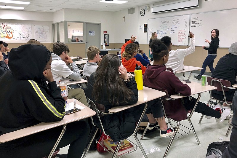 FILE - In this April 15, 2019, file photo, instructors from Raphael House lead a classroom discussion about consent and healthy relationships with a class of sophomores at Central Catholic High School in Portland, Ore. Most young Americans believe in the value of higher education, but many also believe that a high school diploma alone is enough for success, and they view job training as better preparation than any type of college degree, according to a poll by The Associated Press-NORC Center for Public Affairs Research. (AP Photo/Gillian Flaccus, File)