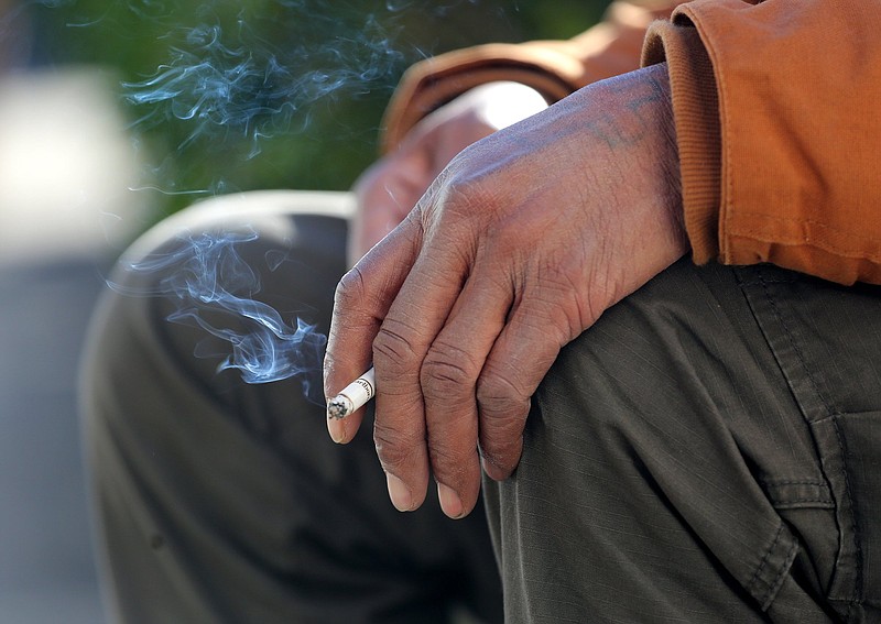 Staff file photo by Erin O. Smith / A man holds a cigarette as he smokes outside the Hamilton County-Chattanooga Courts Building on Jan. 9, 2019.