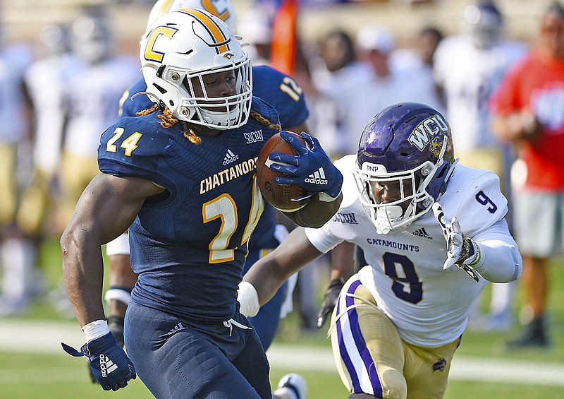 Staff photo by Robin Rudd / UTC's Elijah Ibitokun-Hanks outruns Western Carolina's John Brannon III for a touchdown during the Mocs' 60-36 win Sept. 28 at Finley Stadium. Ibitokun-Hanks was injured during the victory and missed the next four games but returned last Saturday at Samford, where he rushed for 139 yards and scored three touchdowns.