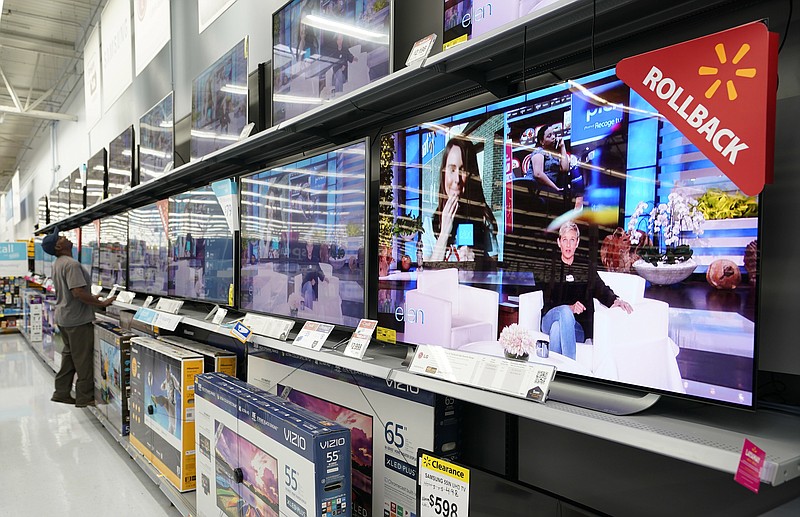 FILE - In this Nov. 9, 2018, file photo shoppers look at televisions at a Walmart Supercenter in Houston. Walmart Inc. reports earnings Thursday, Nov. 14, 2019. (AP Photo/David J. Phillip, File)