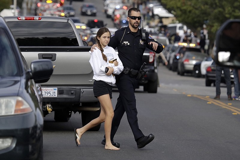A student is escorted out of Saugus High School after reports of a shooting on Thursday, Nov. 14, 2019, in Santa Clarita, Calif. (AP Photo/Marcio Jose Sanchez)